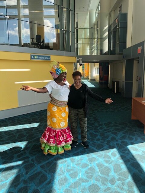 A man and woman in costume dancing inside of an airport.